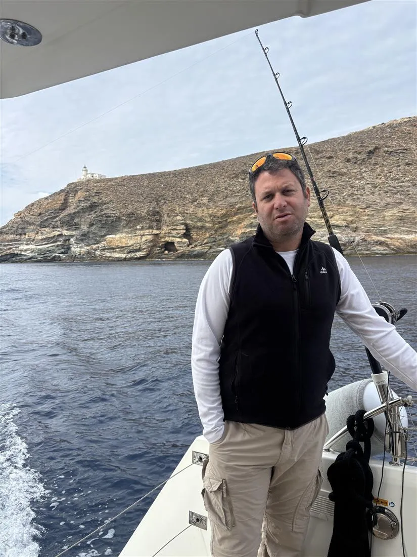Shai Tilinger at the helm station, Greek coastline behind